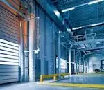 Spacious and modern warehouse interior with parked truck and steel structures.
